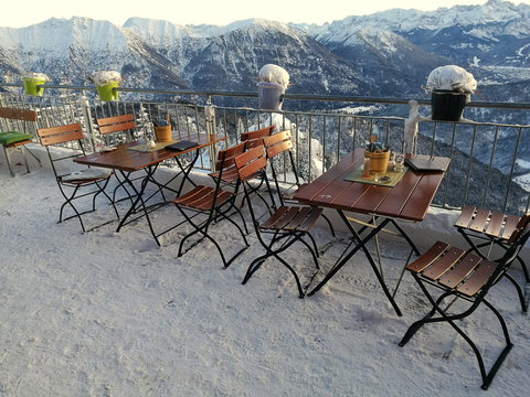 Bistrotische und St&uuml;hle auf der Besucherterrasse auf dem Gipfel des Laber mit viel Schnee und Alpenpanorama in Oberammergau bei Garmisch-Partenkirchen im Winter in Oberbayern im Winter