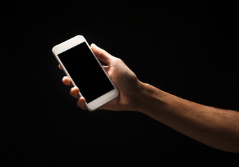 Male hand holding mobile smartphone with blank screen