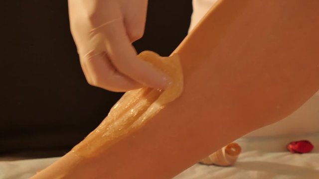 Sugaring epilation skin care with liquid sugar at legs