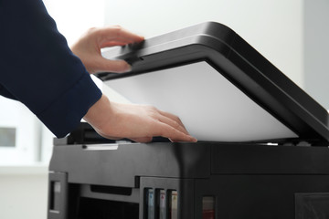 Woman making copy of document in office, closeup