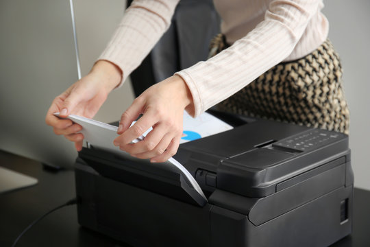 Woman printing document in office, closeup