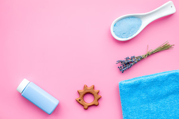 Skin care products for kids with lavender. Bottle, spa salt, towel and toy on pink background top view copy space