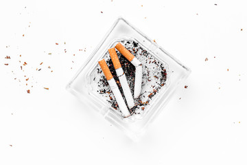 Smoking. Half-smoked cigarettes in ashtray on white background top view copy space