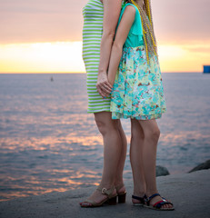 Mother and daughter are standing on the beach