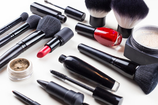 Makeup set of cosmetics with brushes, powder and lipstick is isolated on a white