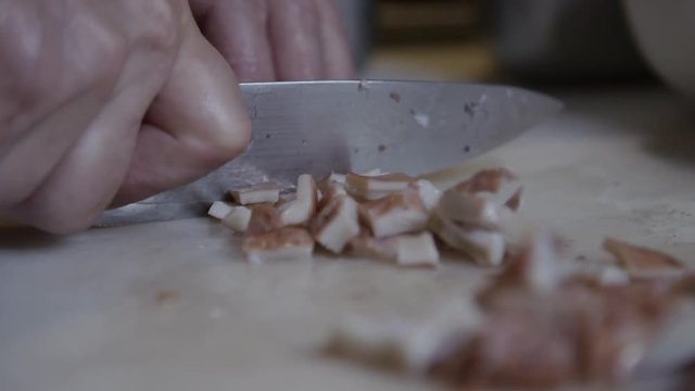 Slow motion close up, chef dices squid tentacles
