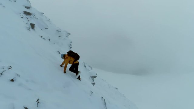 Mountain Climber on a Difficult Ascent Using Ice Axe in a Whiteout