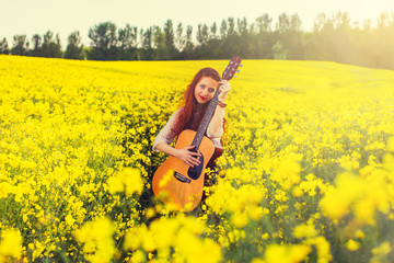 Young ginger hair girl in 70s style with acoustic guitar