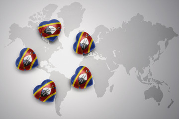 five hearts with national flag of swaziland on a world map background.