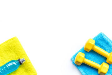 Fitness concept. Sport drink, dumbbells, towel on white background top view copy space