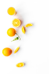 Orange juice in glass near slices of oranges on white background top view copy space