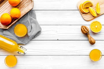 Naklejka na ściany i meble Make orange juice. Juicer, beverage in bottle and glasses near slices of oranges on white wooden background top view copy space