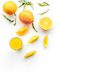 Orange juice in glass near slices of oranges on white background top view copy space