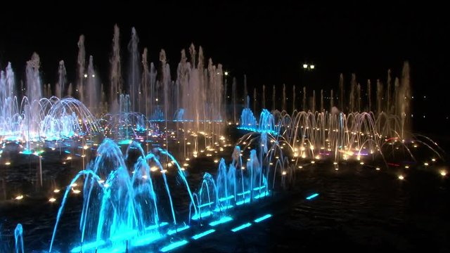 Dancing fountains in Moscow at night. Beautiful views of capital of Russia. Bright colorful water on black sky background in big city.