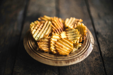 Fresh fried potatoes chips served in the wooden bowl,selective focus