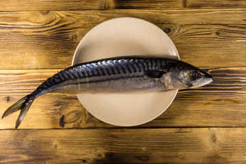 Salted scomber fish on a plate. Whole mackerel on wooden table