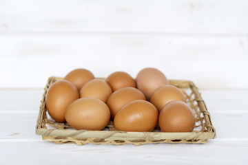 eggs in a basket on a white wooden background