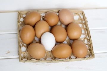 eggs in a basket on a white wooden background