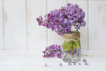 bouquet of purple lilac on a white  wooden background with space for message.