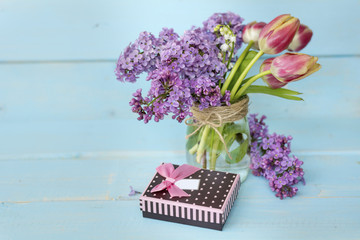 gift box ,lilac and  tulip  flowers in a vase 