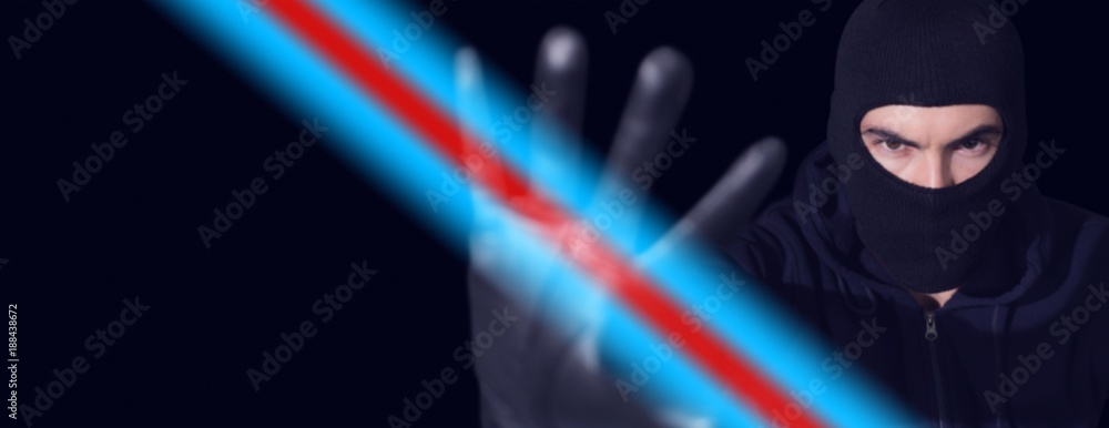 Poster hacker in balaclava gesturing and looking at camera