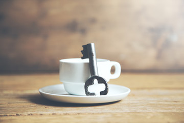 Old key and coffee on table