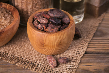 Natural cosmetic oil, sea salt and natural handmade soap with cocoa beans on rustic wooden background