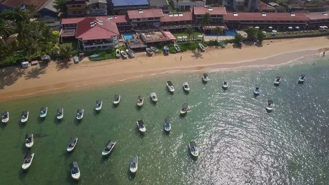 Beautiful view of beach line with boats in the ocean drone footage