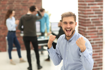 Handsome  businessman celebrating victory shouting happily in th