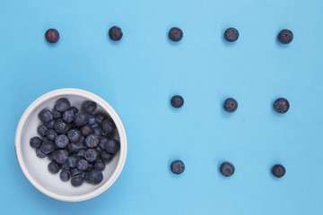 Top view of colorful fruit pattern of fresh blueberries on blue background