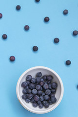 Top view of colorful fruit pattern of fresh blueberries on blue background