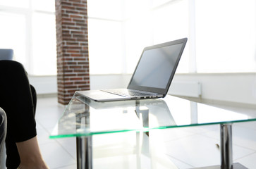 Office workplace with laptop on a glass table in a modern office