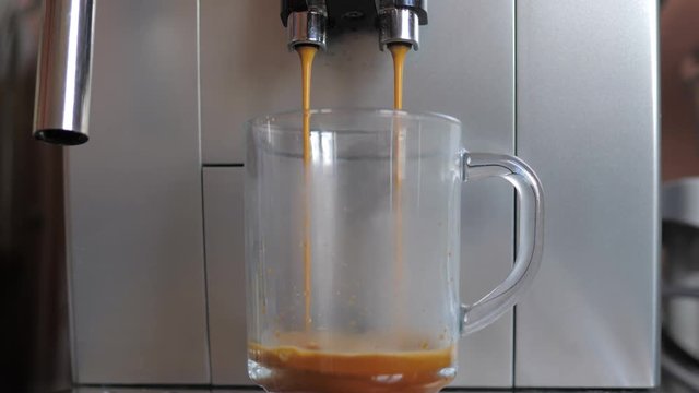 Closeup Shot From The Espresso Machine Or Coffee Maker Pours Coffee In Glass Cup