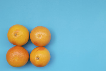 Top view of colorful fruit pattern of fresh orange and grapefruit on blue background