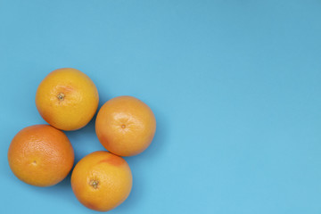 Top view of colorful fruit pattern of fresh orange and grapefruit on blue background