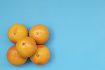 Top view of colorful fruit pattern of fresh orange and grapefruit on blue background