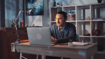 Mates prank their co-worker. Good-looking young male staying in the office late at night notices dark silhouettes gets scared. Paranormal activity, unreal. Close up view