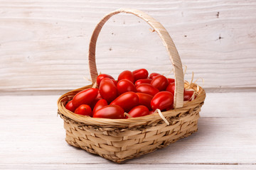 Cherry tomatoes in a basket on a rustic background