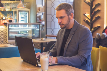 Businessman working in laptop in cafe