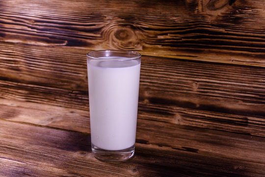 Full glass of milk on a wooden table