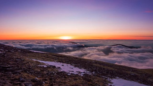 Mountain sunset timelapse with moving blanket of clouds.