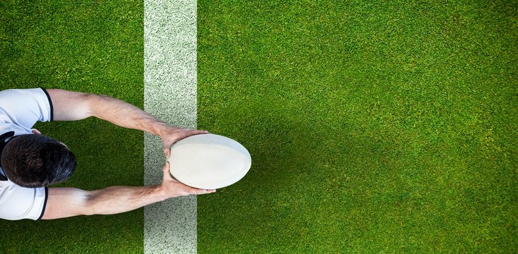 Composite image of high angle view of man holding rugby ball