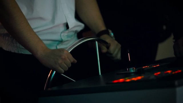 The captain at the controls of a modern ship in a dark room. Close up