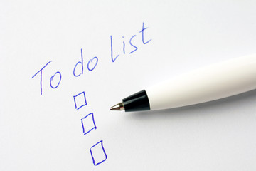 to do list on a white sheet of paper, pen notes completed check box. self management concept, close up, selective focus