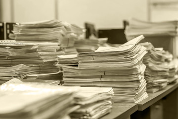 bundles bales of paper documents. stacks packs pile on the desk in the office in black and white. mountain of waste paper
