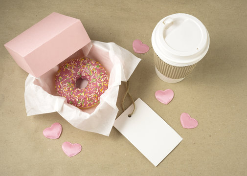 Love at first bite / Creative valentine concept photo of donut with take away coffee on brown background.