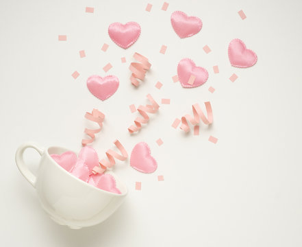 Splash of love / Creative valentine concept photo of coffee cup splashing with hearts and confetti on white background.