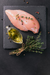 Raw chicken fillets with spices and herbs.