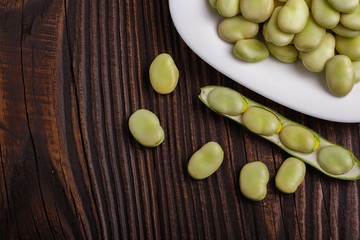 fresh broad beans on a rustic background