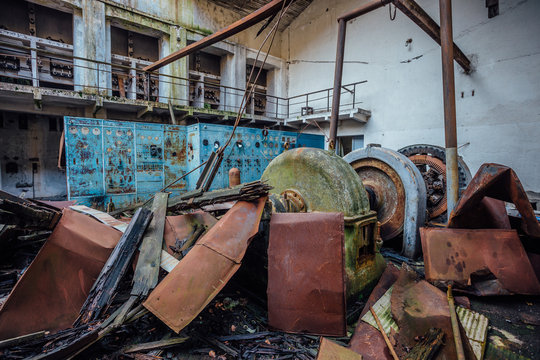 Ruined abandoned hydroelectric power plant. Rusty generator at machinery. Demolished roof. Gagra, Abkhazia